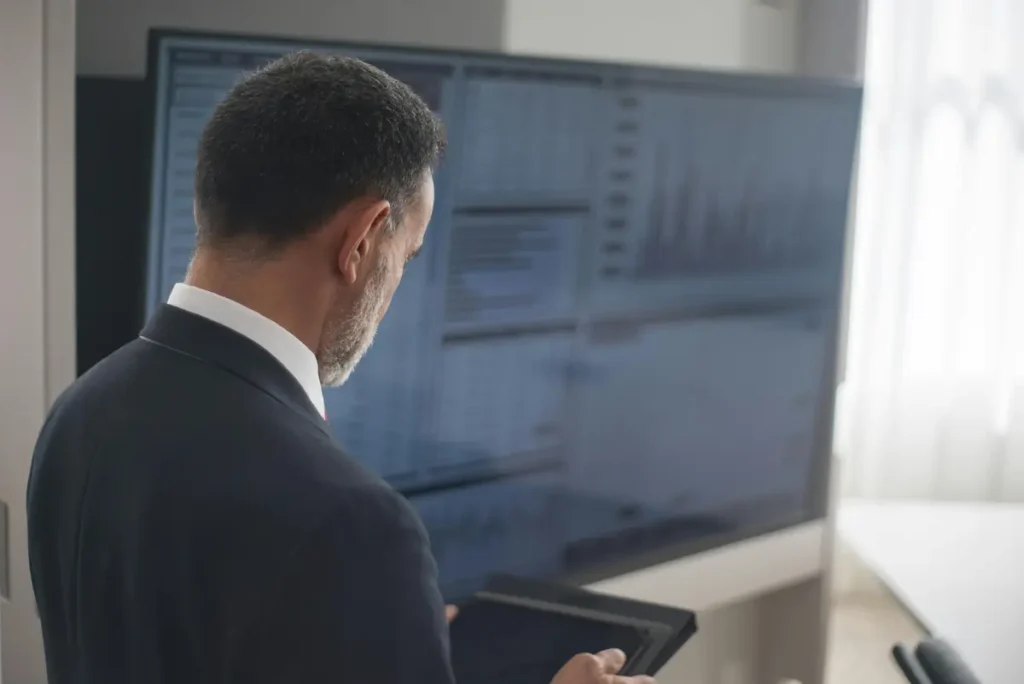 A person analyzing data by looking at financial charts, illustrating modern risk management and dynamic pricing in the receivables market.